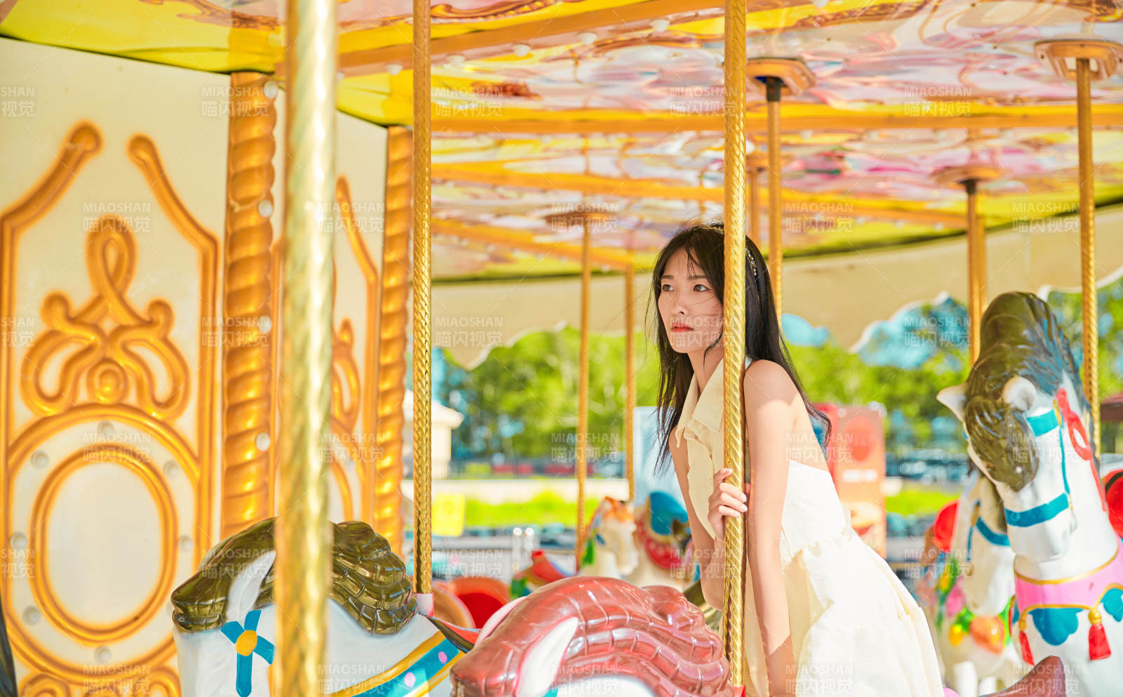 在游樂園坐旋轉(zhuǎn)木馬的可愛少女