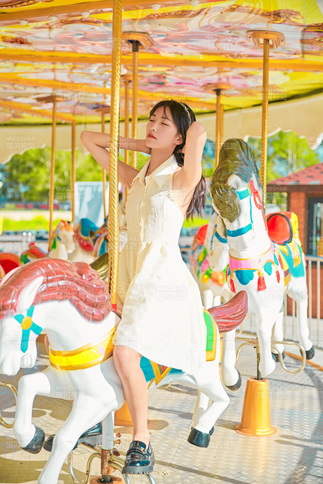 在游乐园坐旋转木马的可爱少女