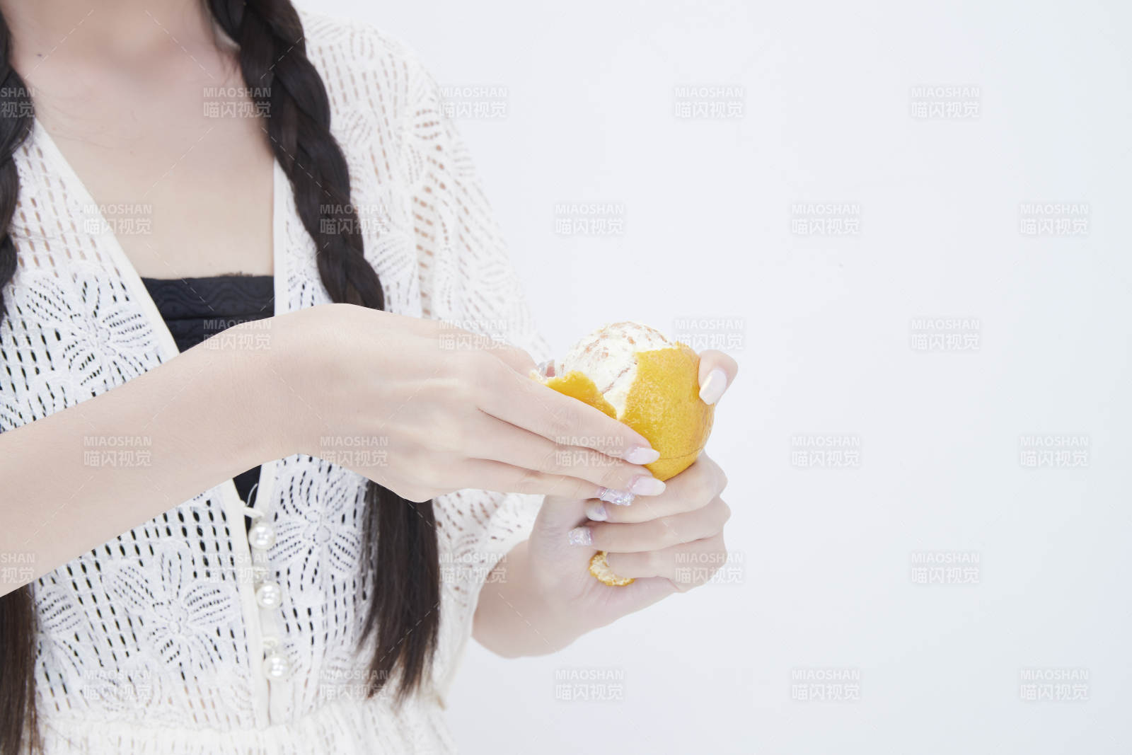 在剝橙子皮的身穿鏤空連衣裙的亞洲少女人像