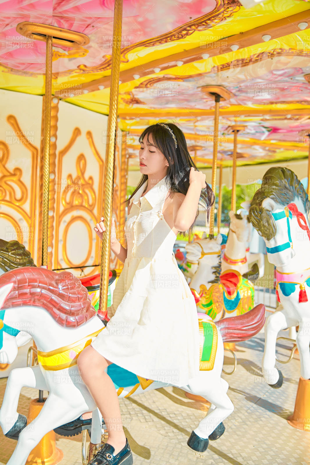 在游乐园坐旋转木马的可爱少女