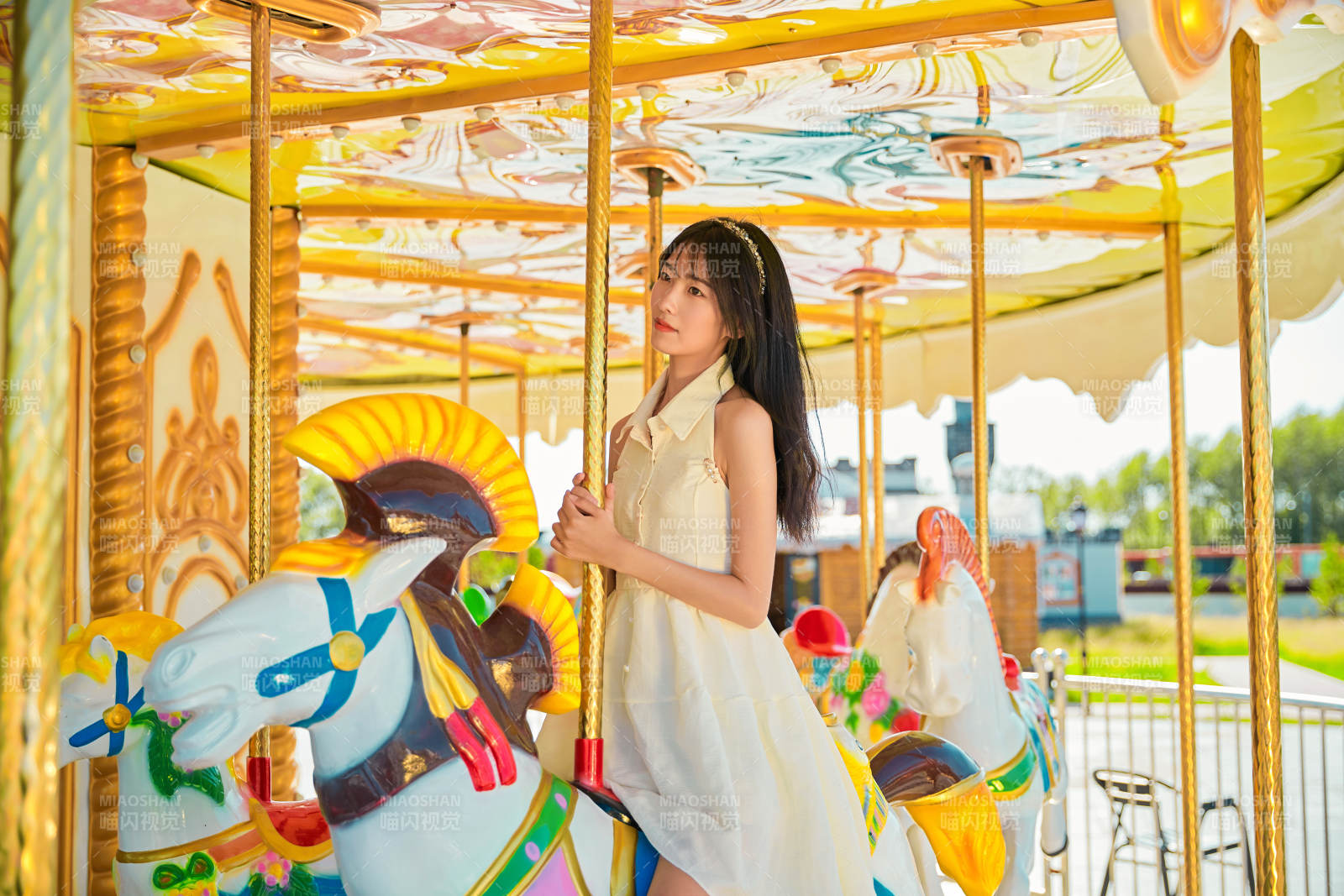 在游樂園坐旋轉(zhuǎn)木馬的可愛少女