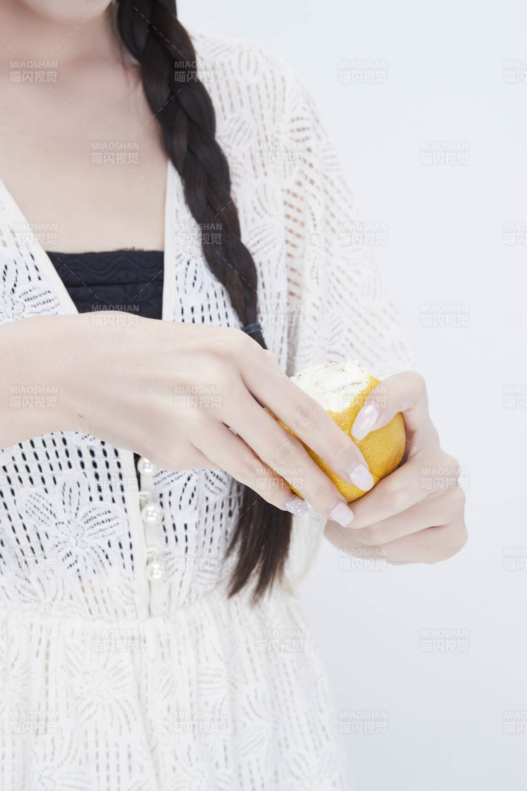 在剝橙子皮的身穿鏤空連衣裙的亞洲少女人像