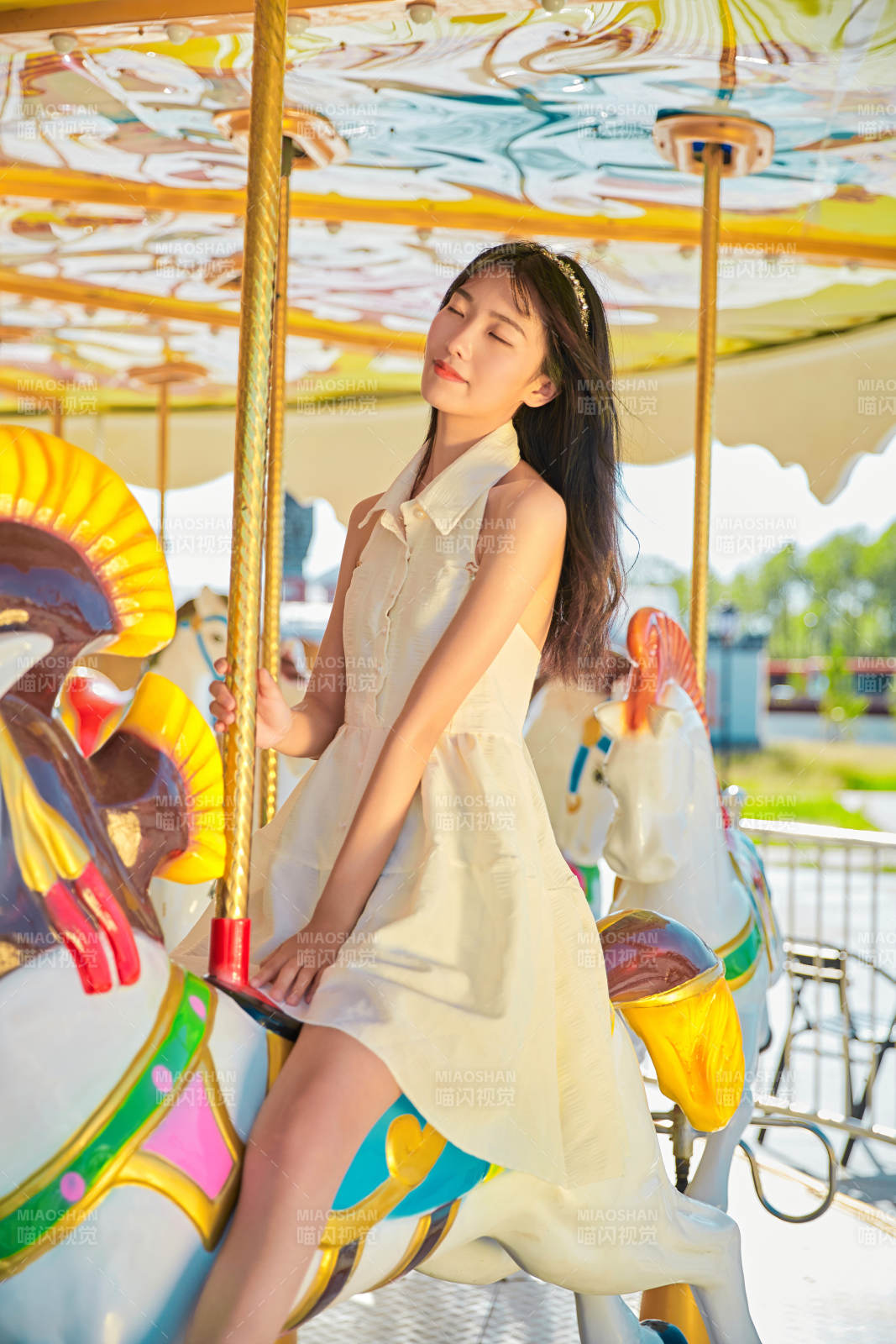 在游樂園坐旋轉木馬的可愛少女