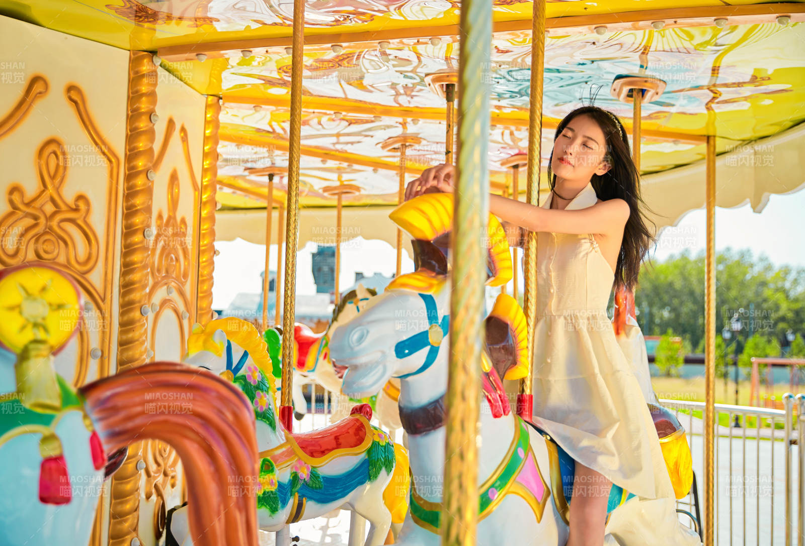 在游樂園坐旋轉木馬的可愛少女