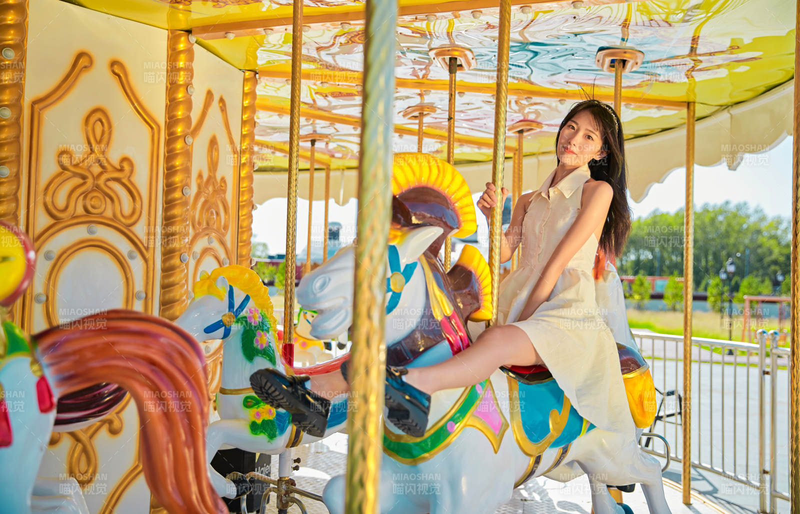 在游樂園坐旋轉木馬的可愛少女