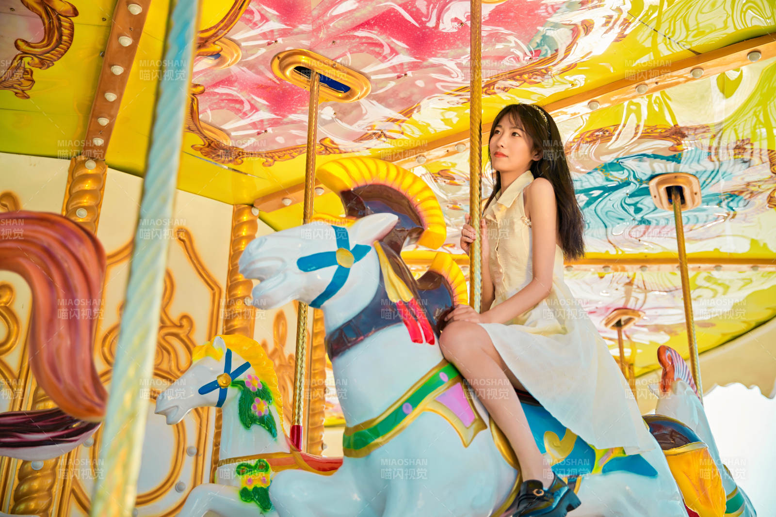 在游乐园坐旋转木马的可爱少女