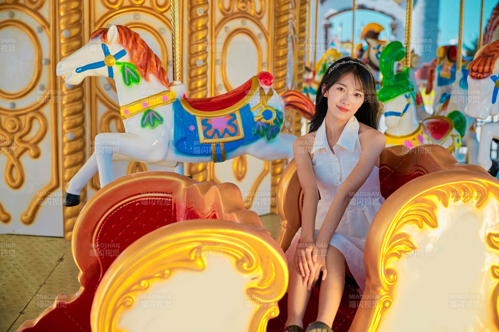 在游樂園坐旋轉(zhuǎn)木馬的可愛少女