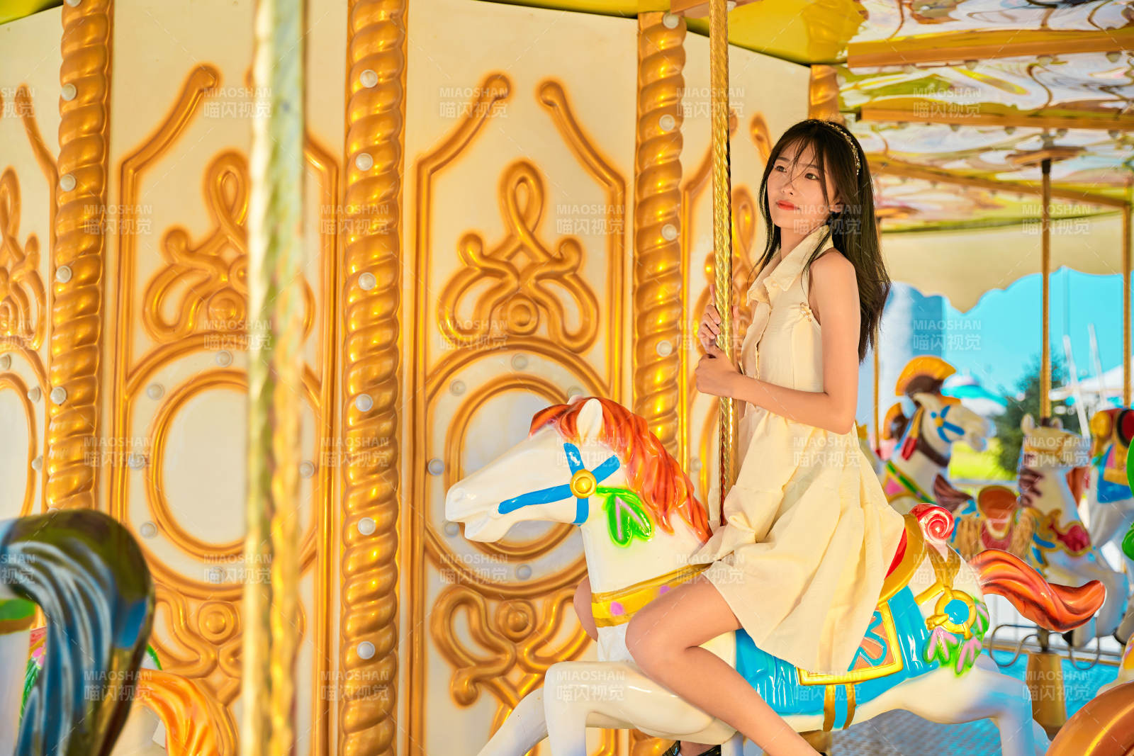 在游樂園坐旋轉(zhuǎn)木馬的可愛少女