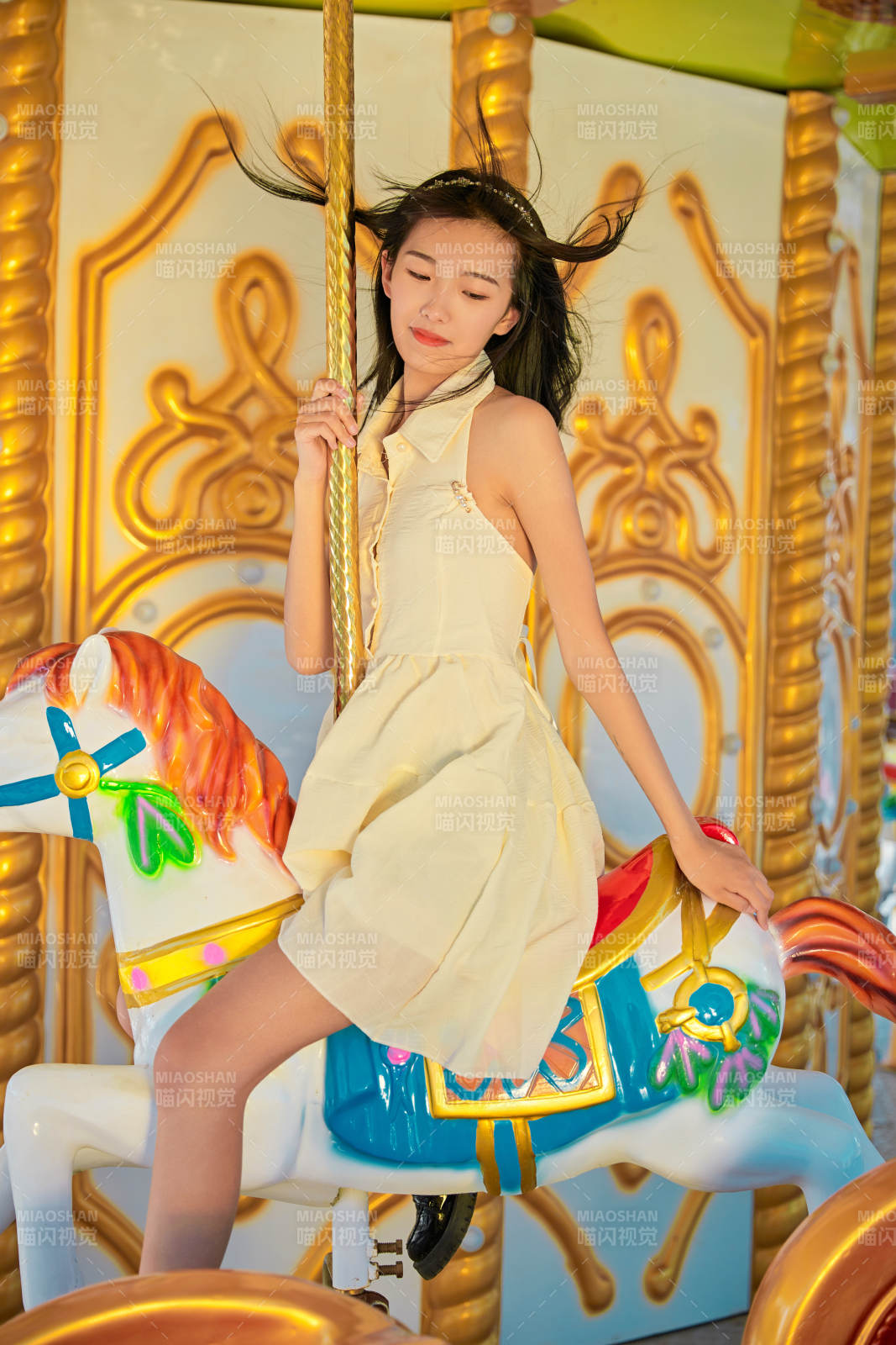 在游樂(lè)園坐旋轉(zhuǎn)木馬的可愛(ài)少女