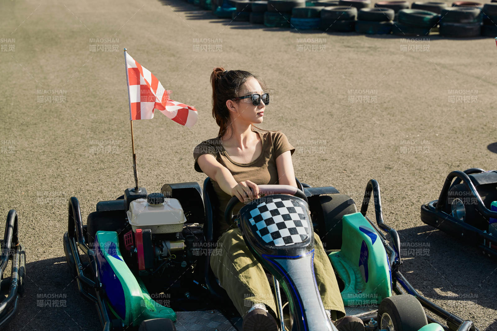 在游樂場卡丁賽道上駕駛卡丁車的美女