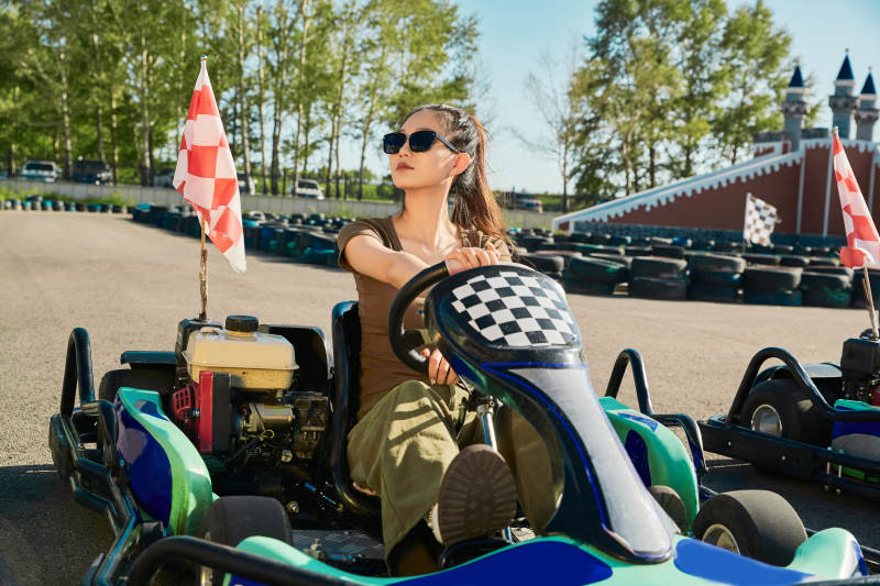 在游乐场卡丁赛道上驾驶卡丁车的美女