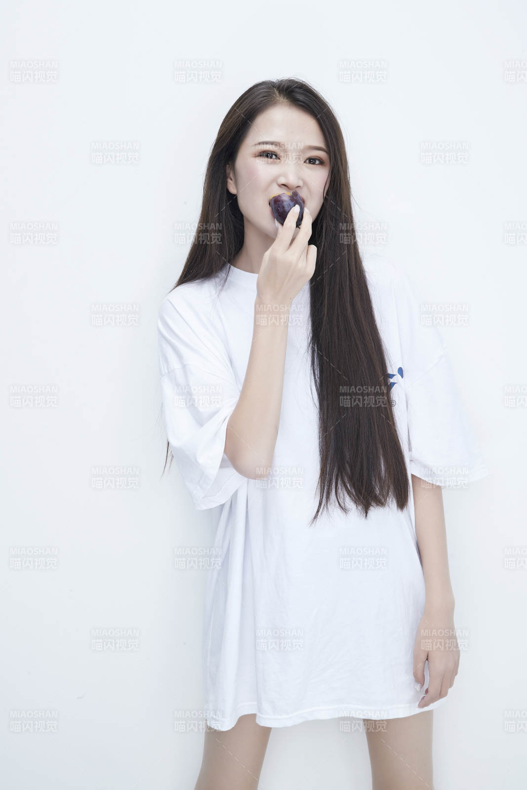 吃西梅的身穿白色長T血襯衫的長發少女人像