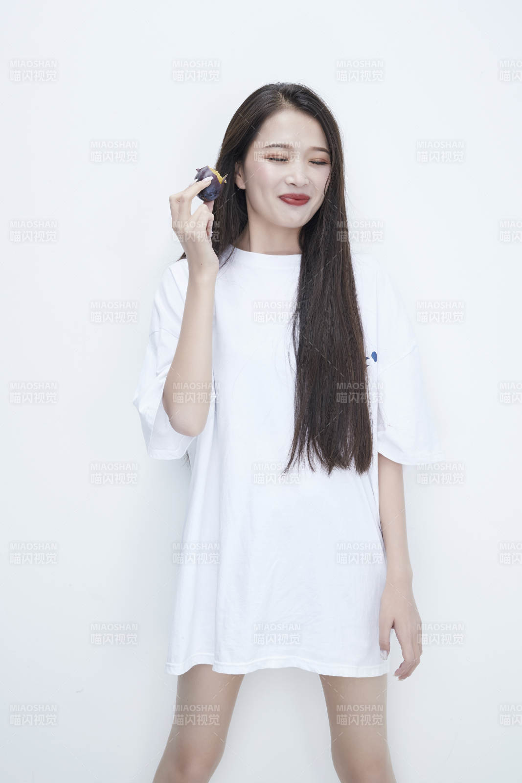 吃西梅的身穿白色長(zhǎng)T血襯衫的長(zhǎng)發(fā)少女人像