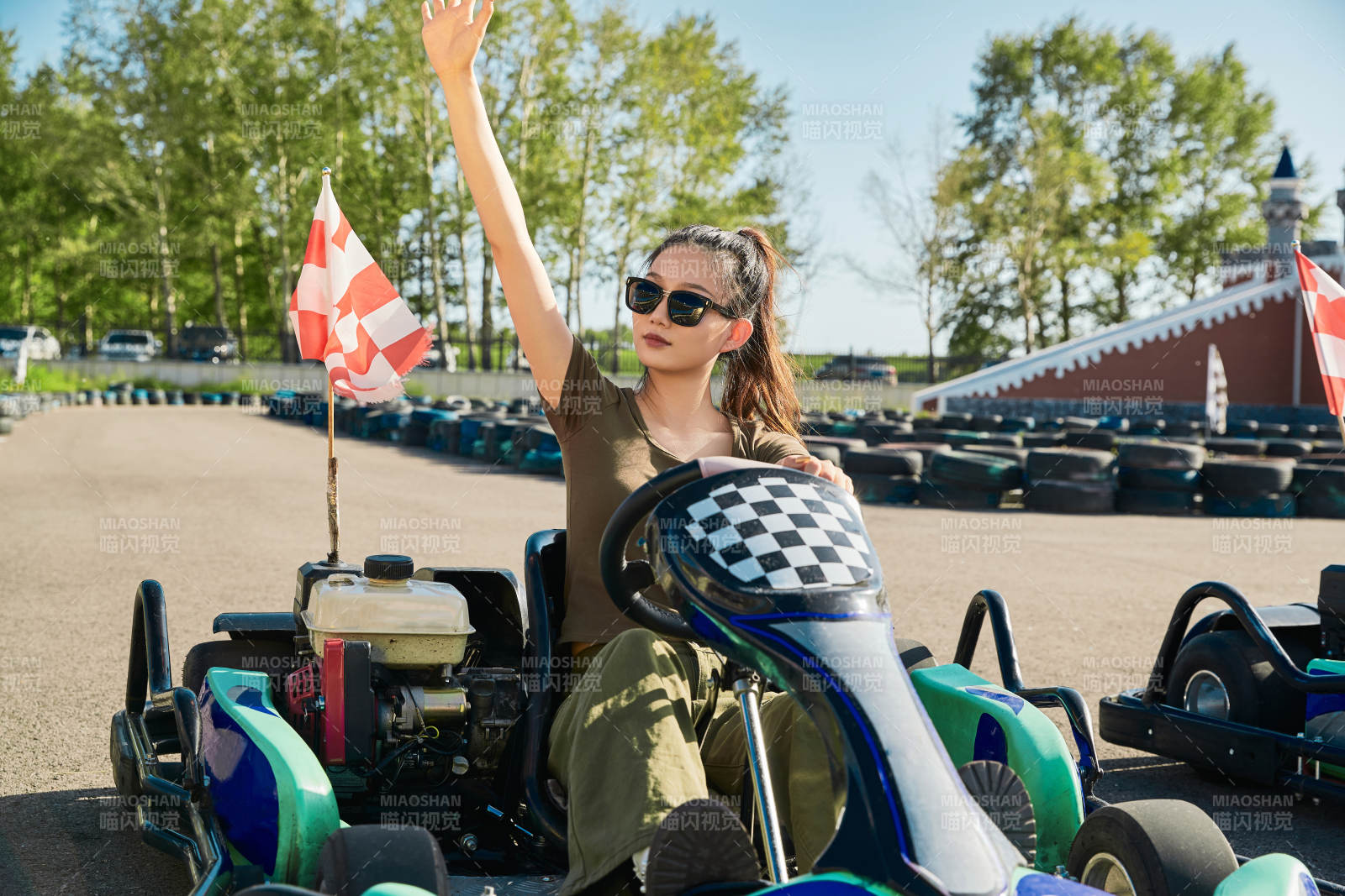 在游樂場卡丁賽道上駕駛卡丁車的美女