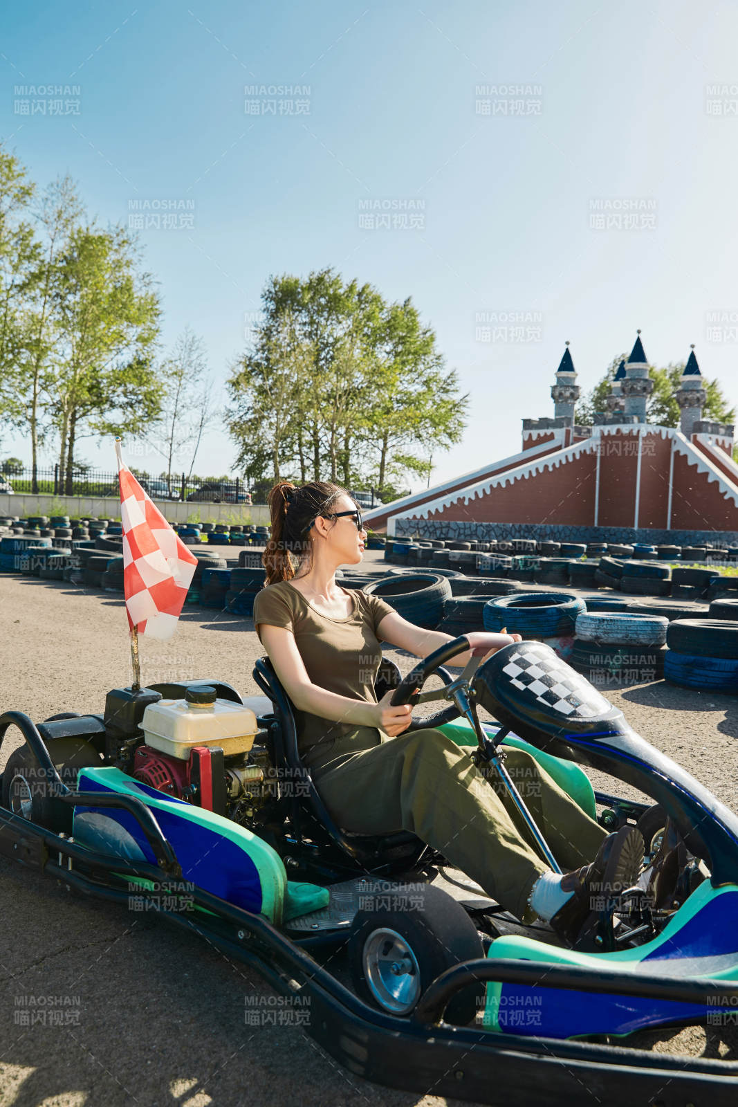 在游樂場卡丁賽道上駕駛卡丁車的美女