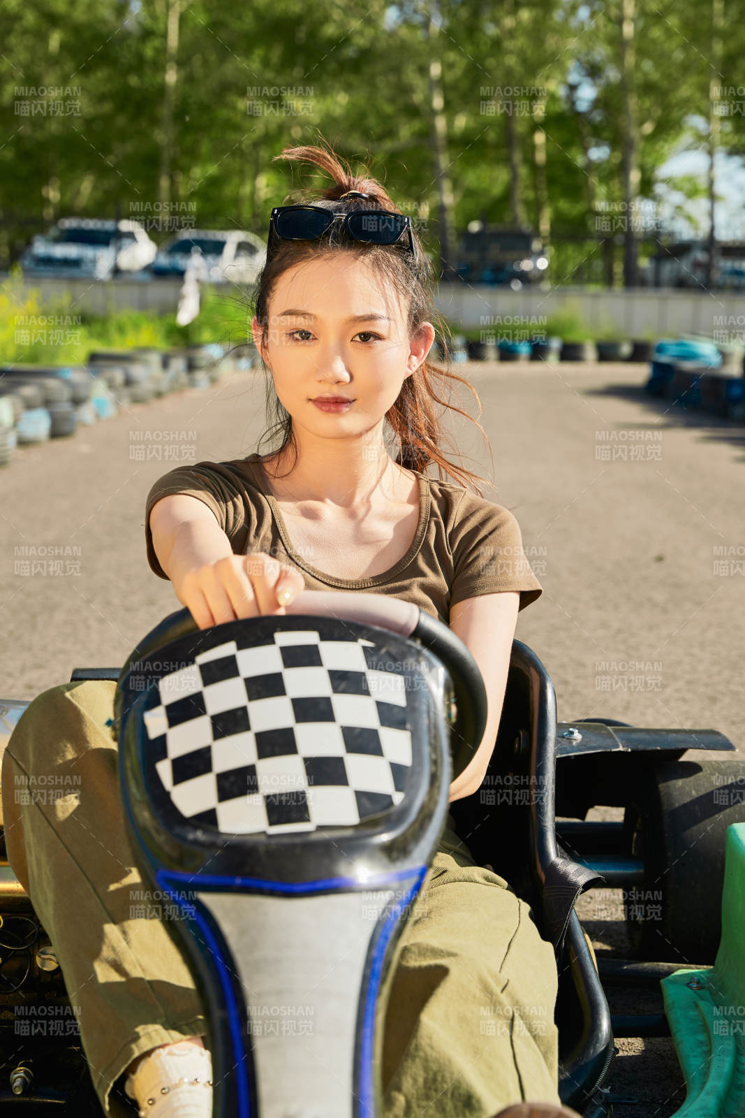 在游樂場卡丁賽道上駕駛卡丁車的美女