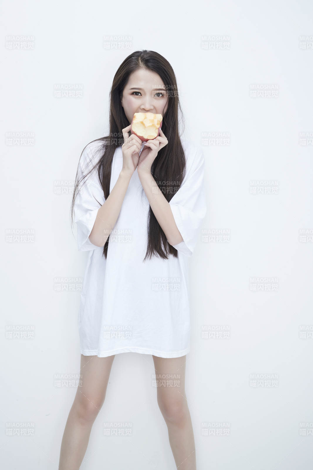 吃蘋果的穿白色長T血衫的長發(fā)可愛少女人像