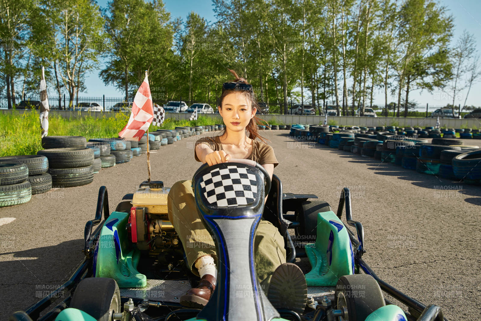 在游樂場卡丁賽道上駕駛卡丁車的美女