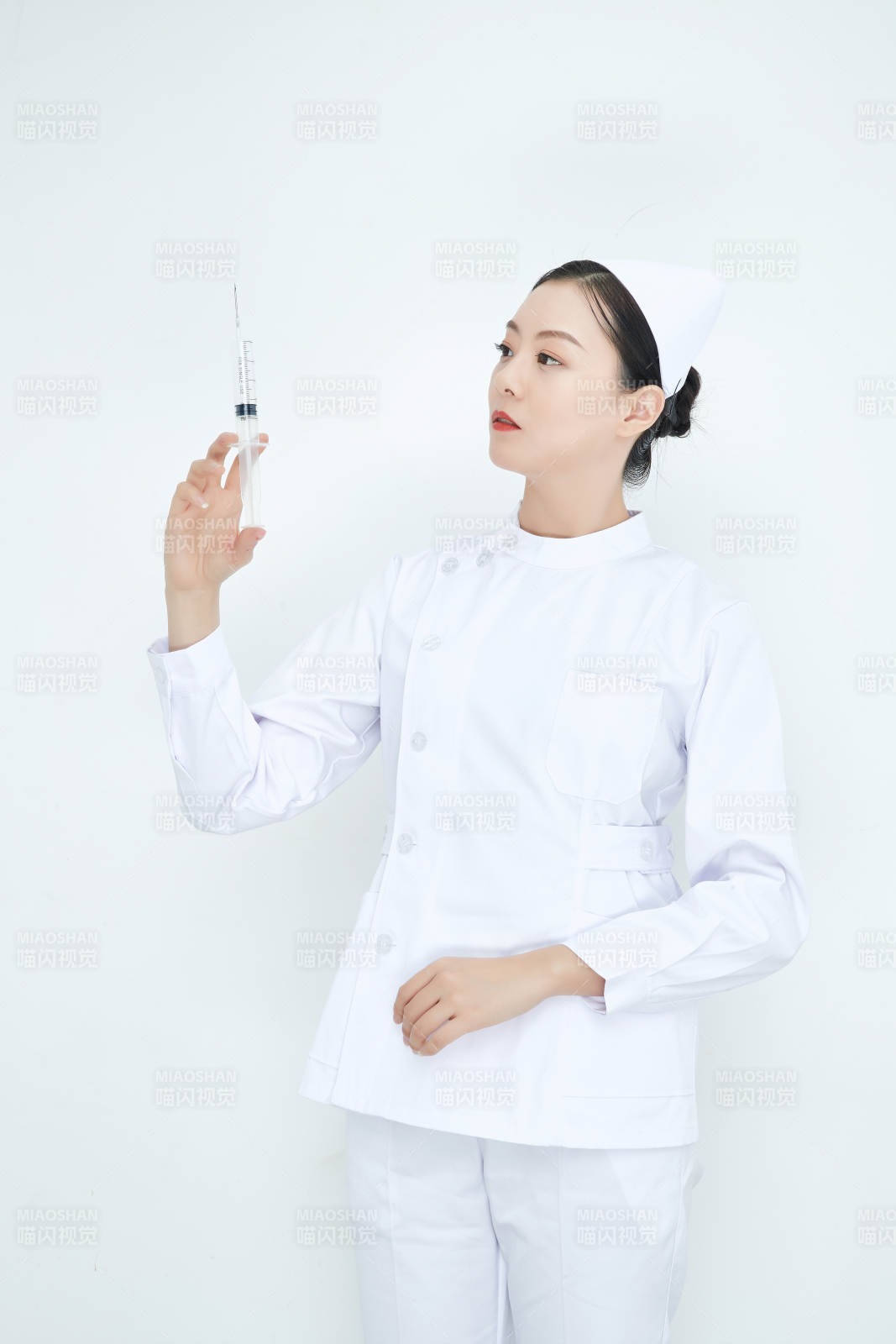穿護(hù)士服戴口罩手執(zhí)針筒的年輕女護(hù)士
