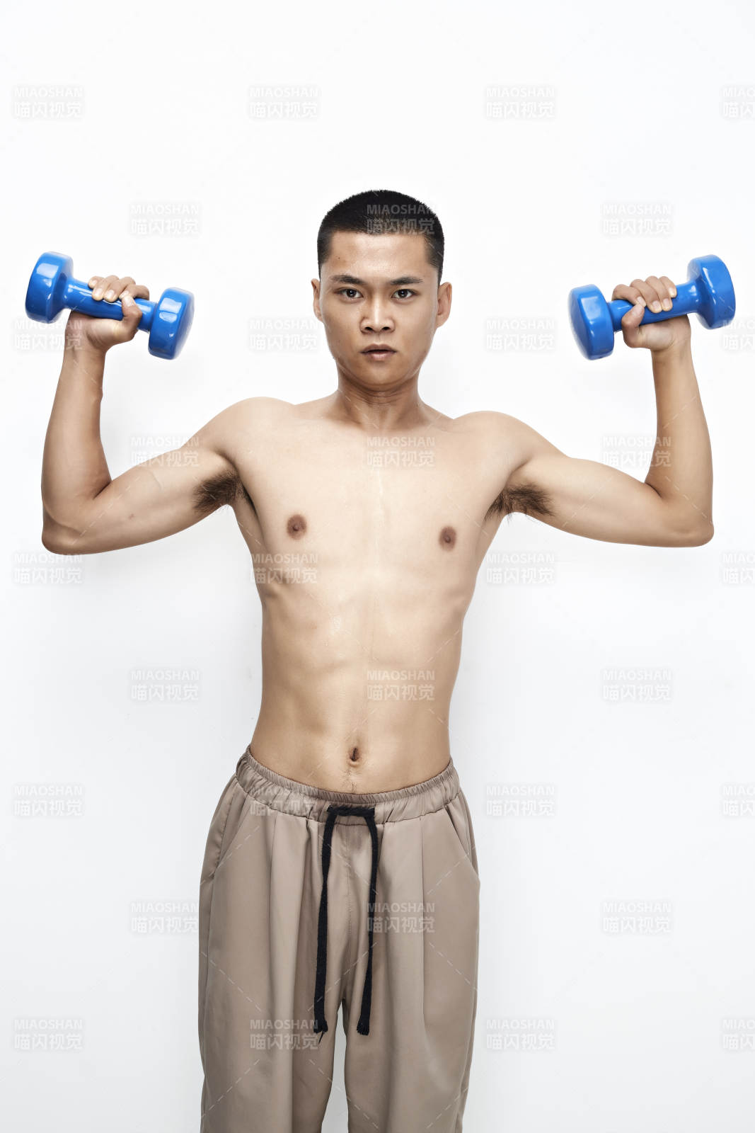 使用哑铃进行健身锻炼的亚洲男性