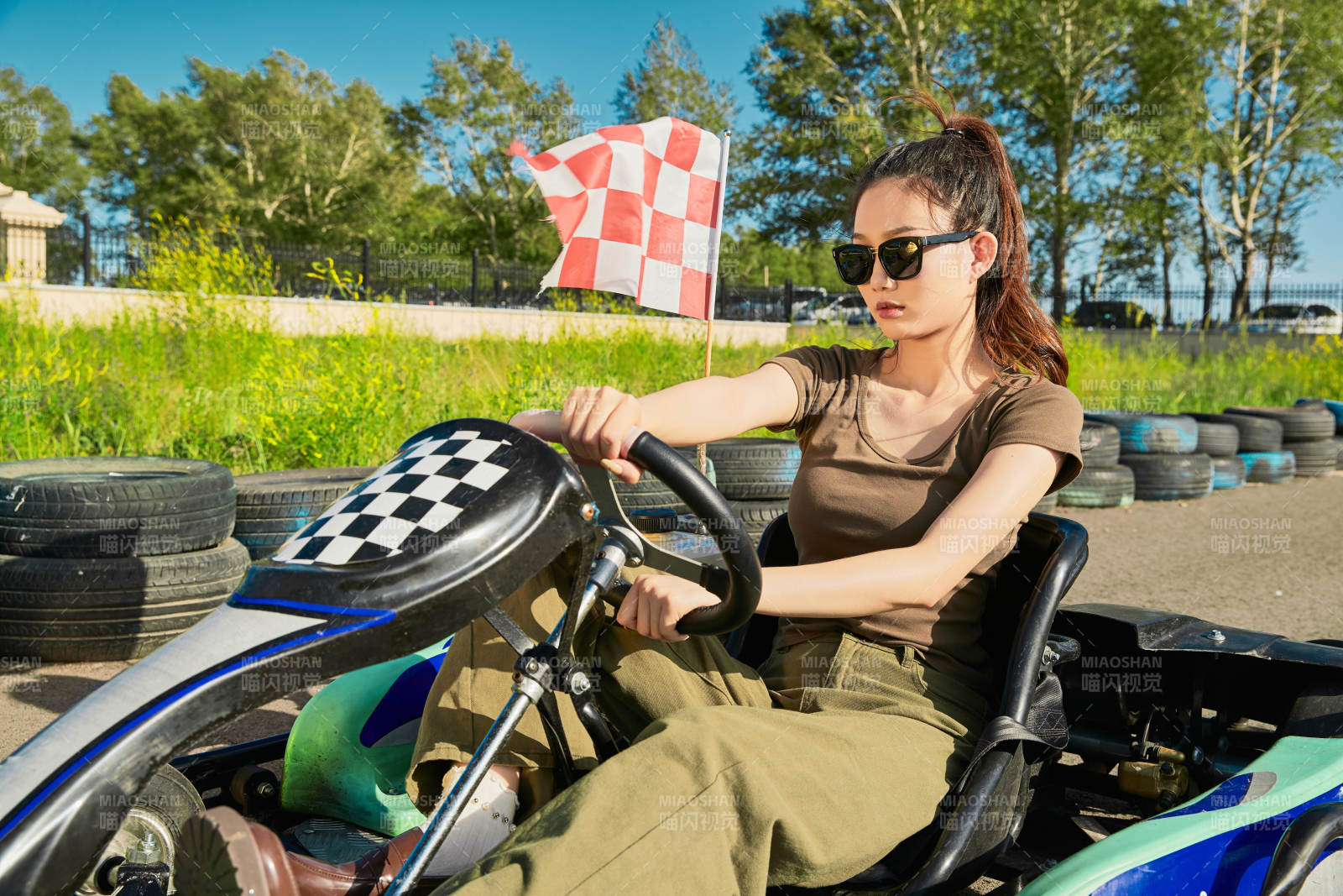 在游樂場卡丁賽道上駕駛卡丁車的美女