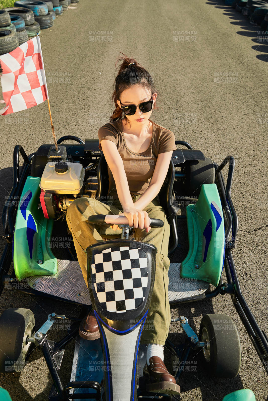 在游樂場卡丁賽道上駕駛卡丁車的美女