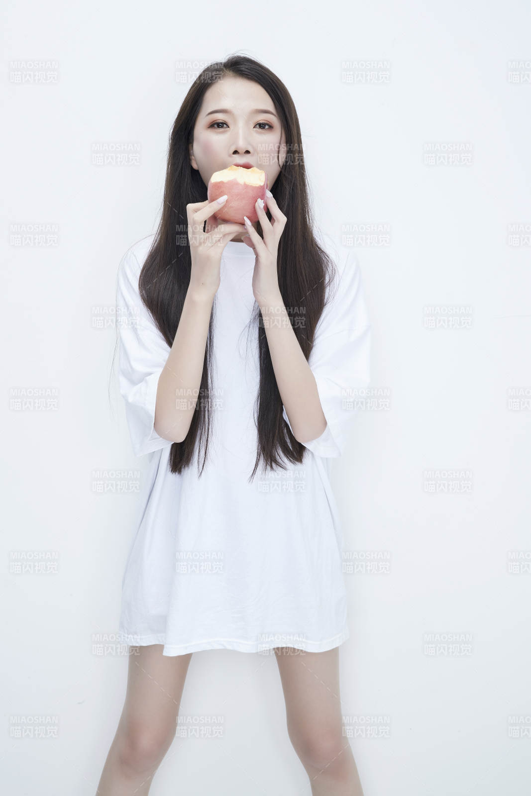吃蘋果的穿白色長T血衫的長發(fā)可愛少女人像