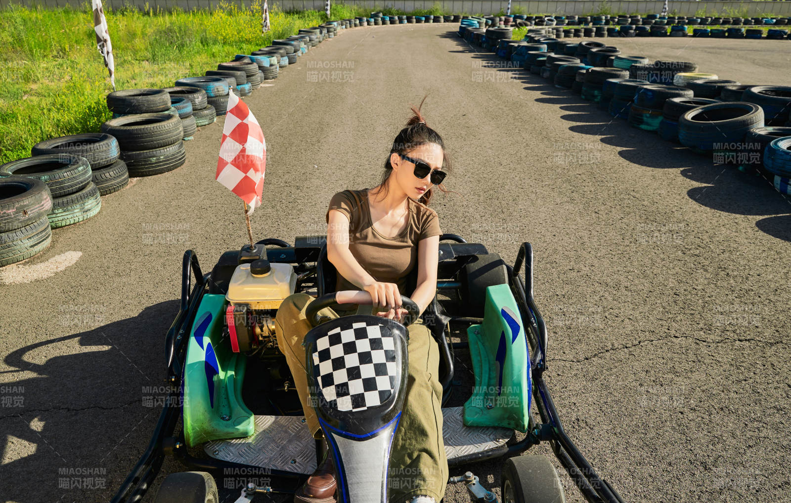 在游樂場卡丁賽道上駕駛卡丁車的美女