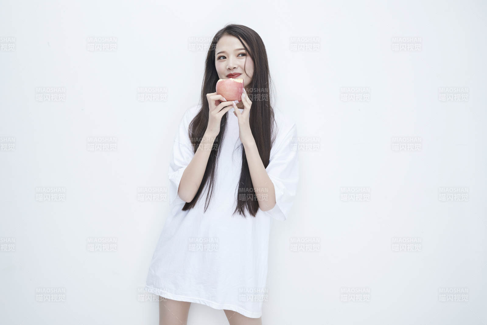 吃苹果的穿白色长T血衫的长发可爱少女人像