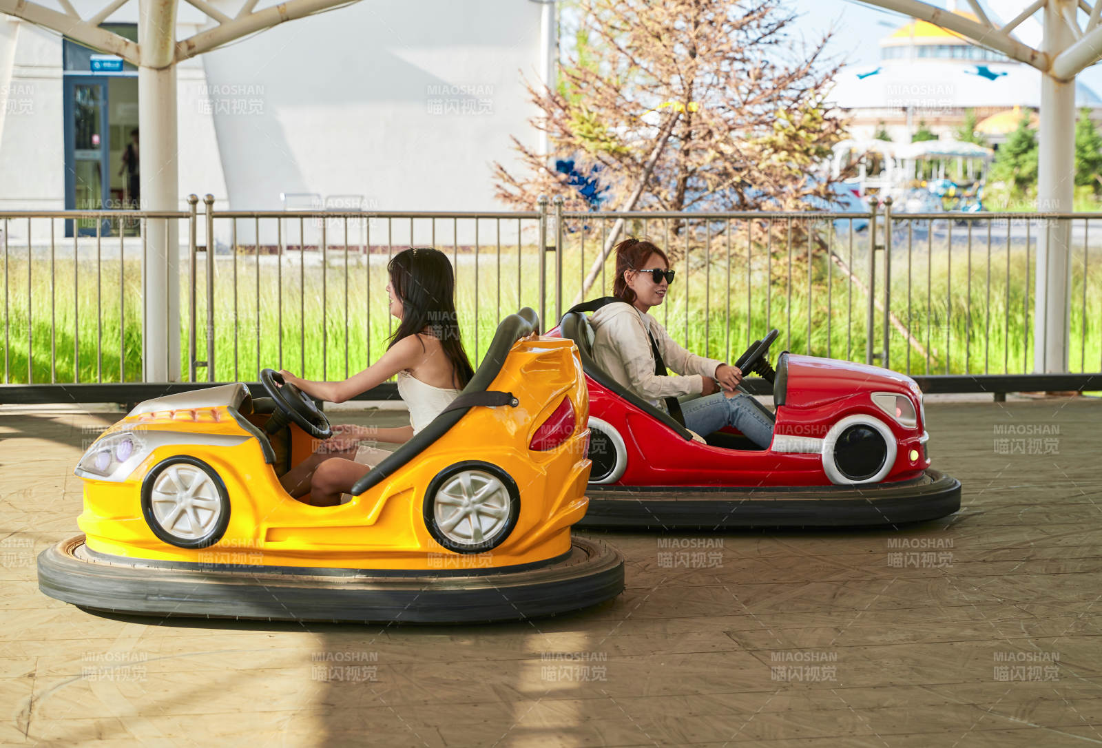 在游樂(lè)園玩碰碰車的閨蜜美女