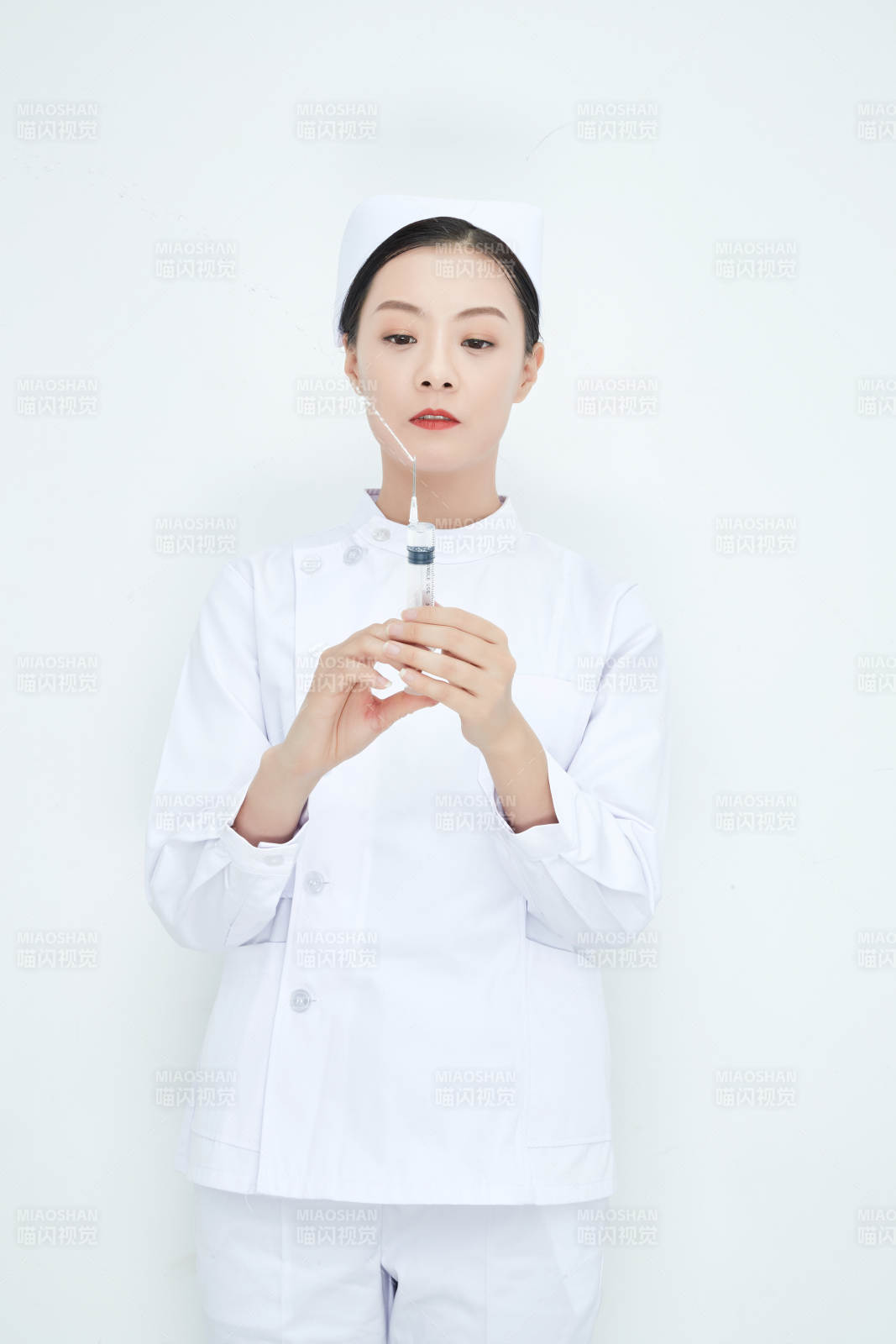 穿護(hù)士服戴口罩手執(zhí)針筒的年輕女護(hù)士