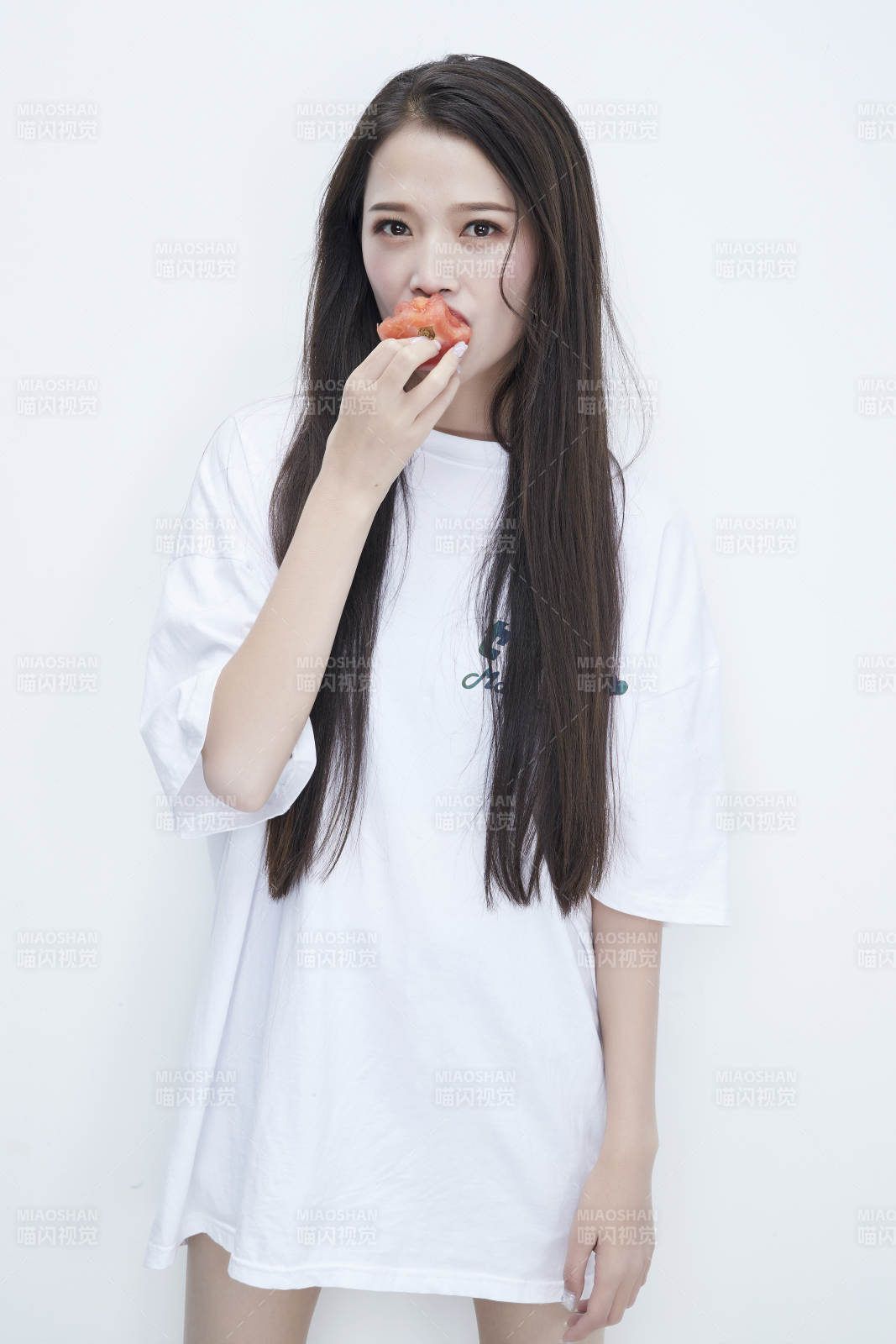 吃番茄的身穿白色長(zhǎng)T血襯衫的長(zhǎng)發(fā)少女人像