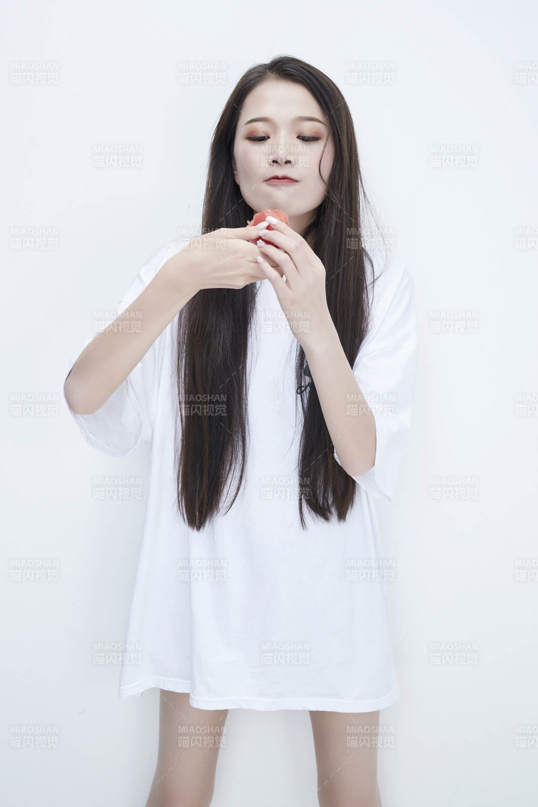 吃番茄的身穿白色長T血襯衫的長發少女人像