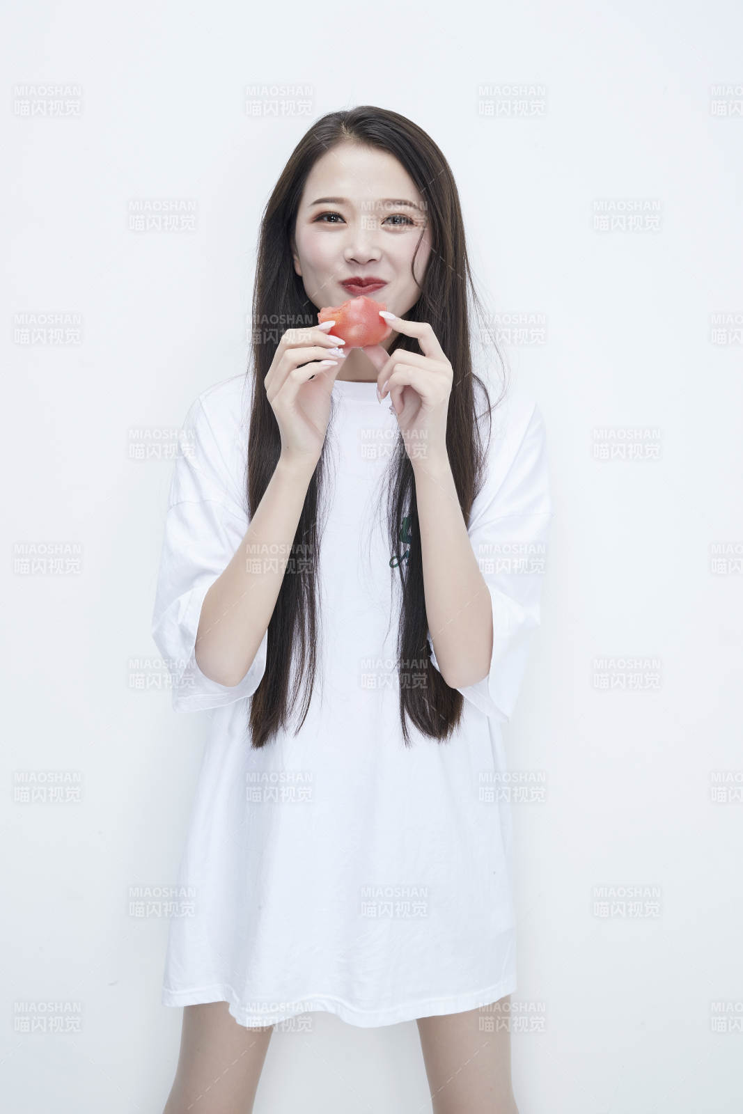 吃番茄的身穿白色長T血襯衫的長發少女人像