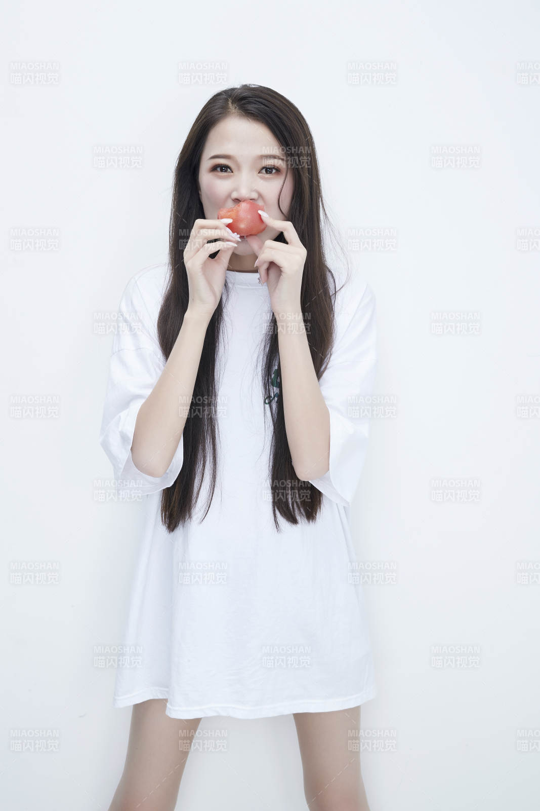 吃番茄的身穿白色長T血襯衫的長發少女人像