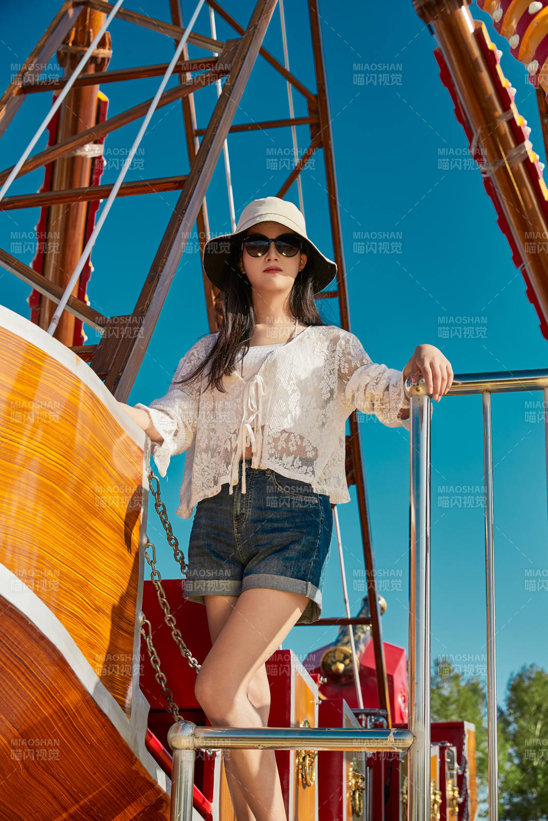 站在游樂場海盜船旁邊的美女