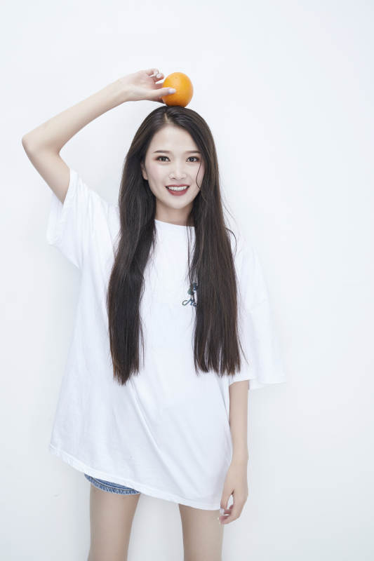 玩耍橙子穿白色長T血的亞洲可愛少女人像