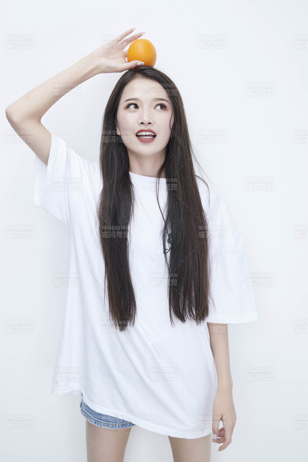 玩耍橙子穿白色长T血的亚洲可爱少女人像