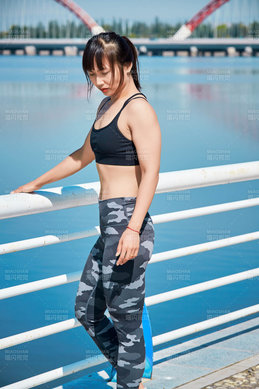 戶外河畔公園做拉伸有氧運動的亞洲女性