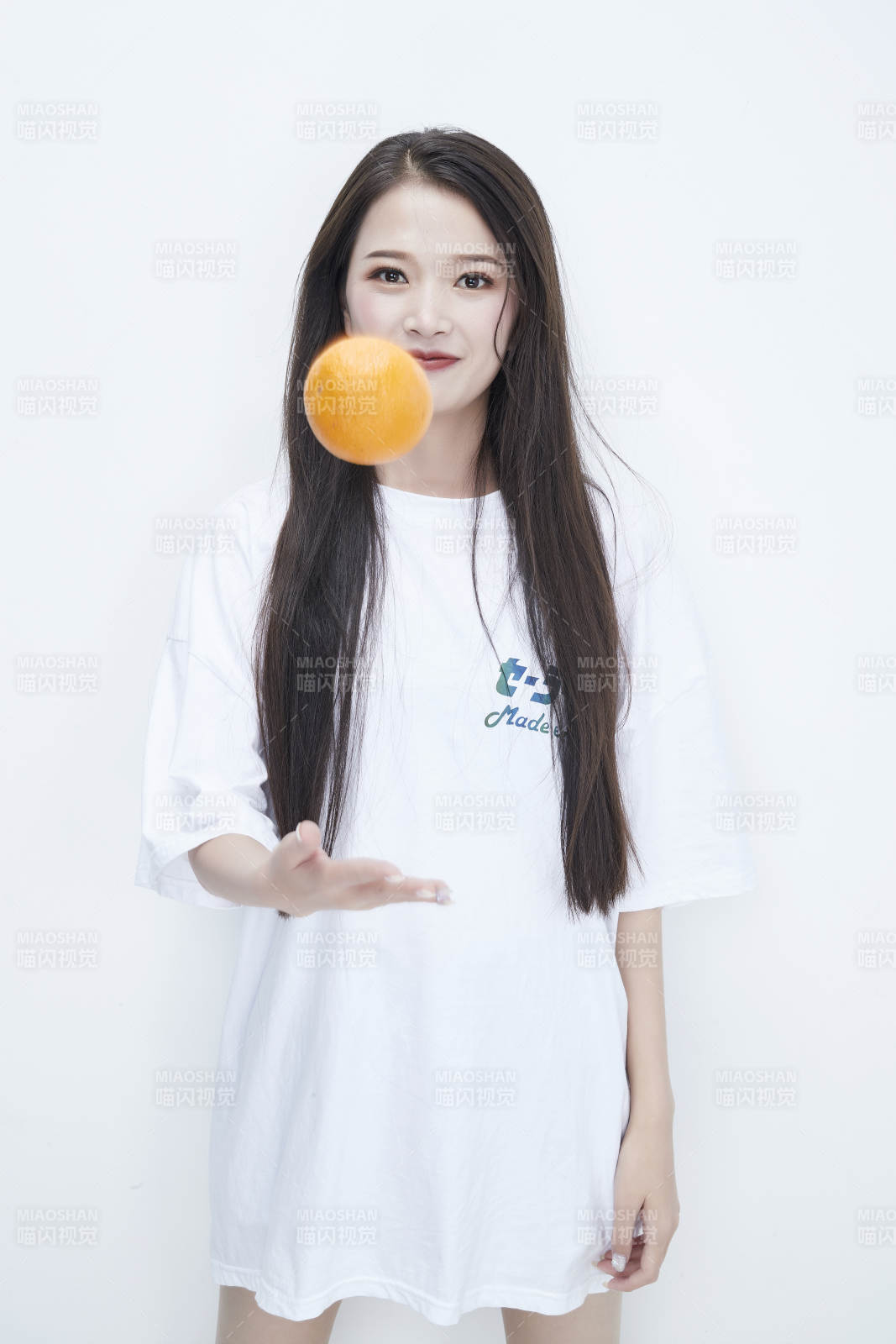 玩耍橙子穿白色長T血的亞洲可愛少女人像