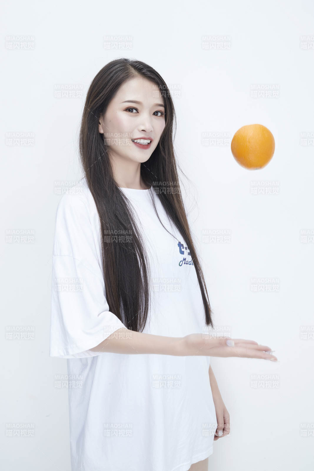 玩耍橙子穿白色長T血的亞洲可愛少女人像