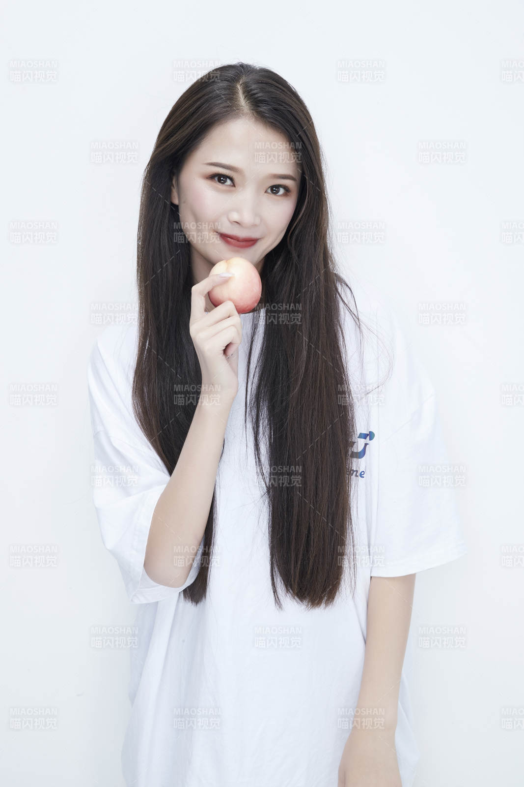 吃桃子的穿白色长T血衫的长发可爱少女人像图片