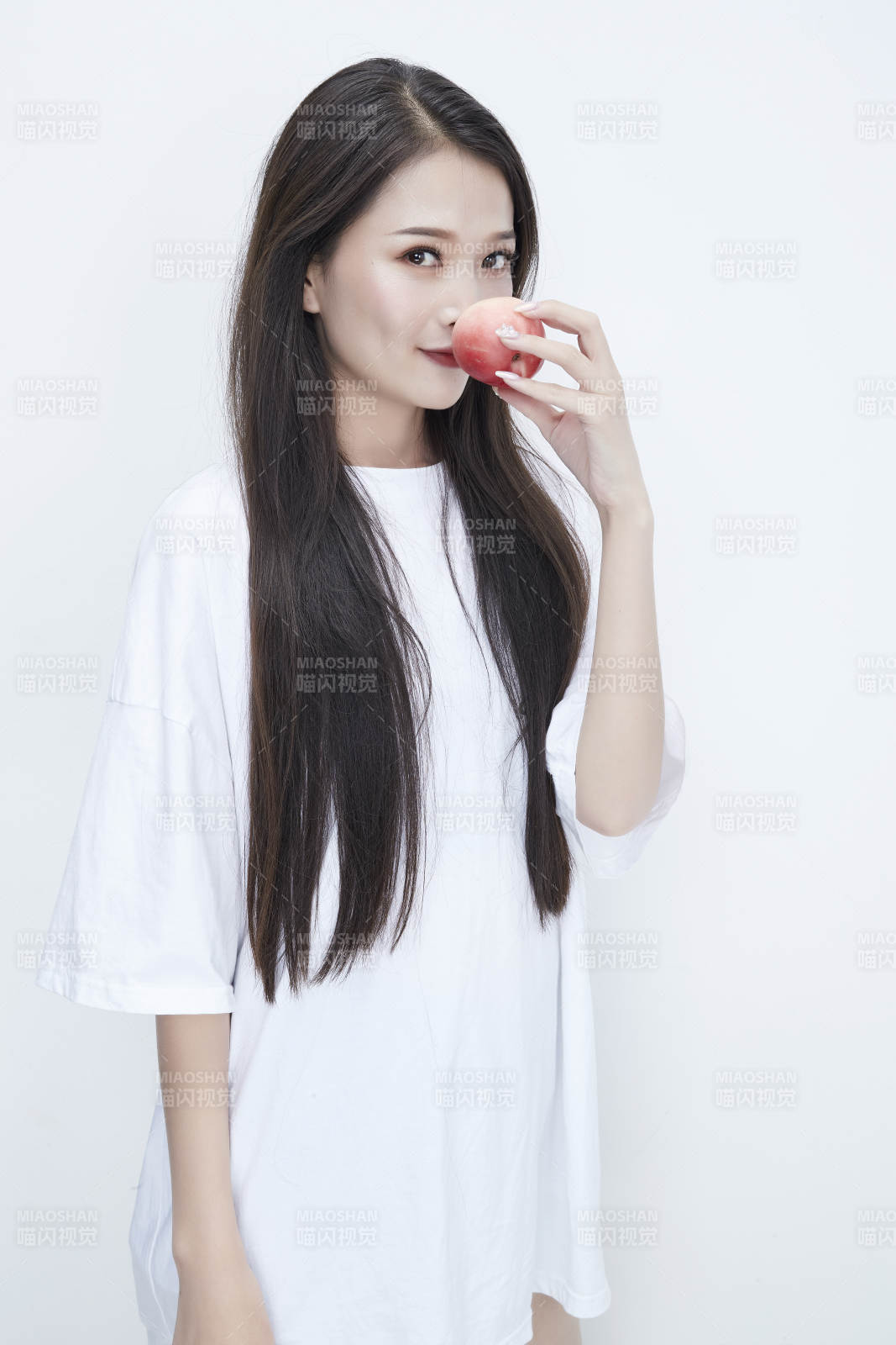 吃桃子的穿白色长T血衫的长发可爱少女人像图片