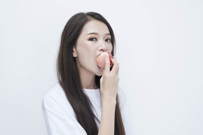 吃桃子的穿白色长T血衫的长发可爱少女人像