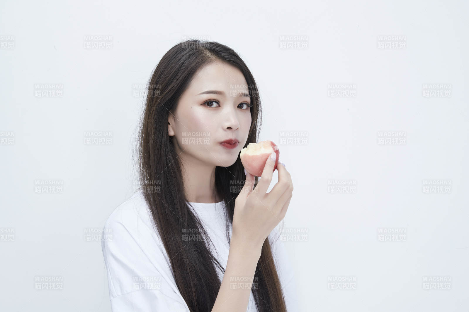 吃桃子的穿白色长T血衫的长发可爱少女人像图片