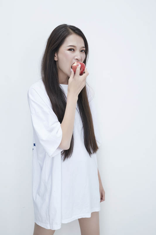 吃桃子的穿白色长T血衫的长发可爱少女人像