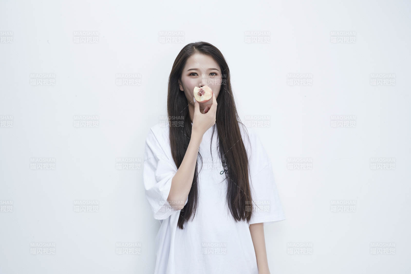 吃桃子的穿白色长T血衫的长发可爱少女人像图片