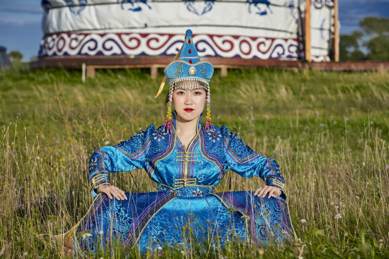 草原蒙古包前身穿豪华蒙古族服饰的蒙族少女