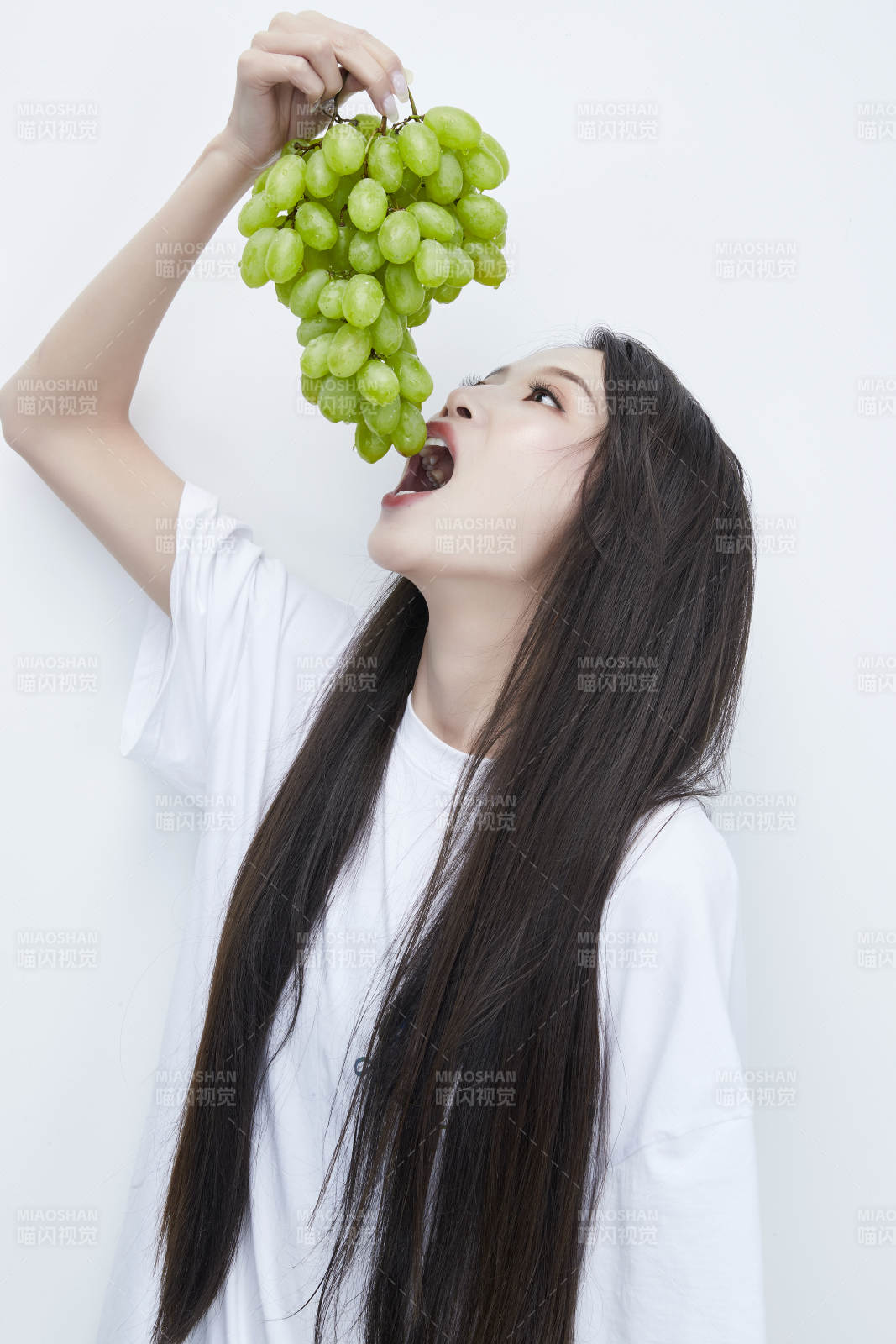 吃葡萄的穿白色長T血衫的長發可愛少女人像