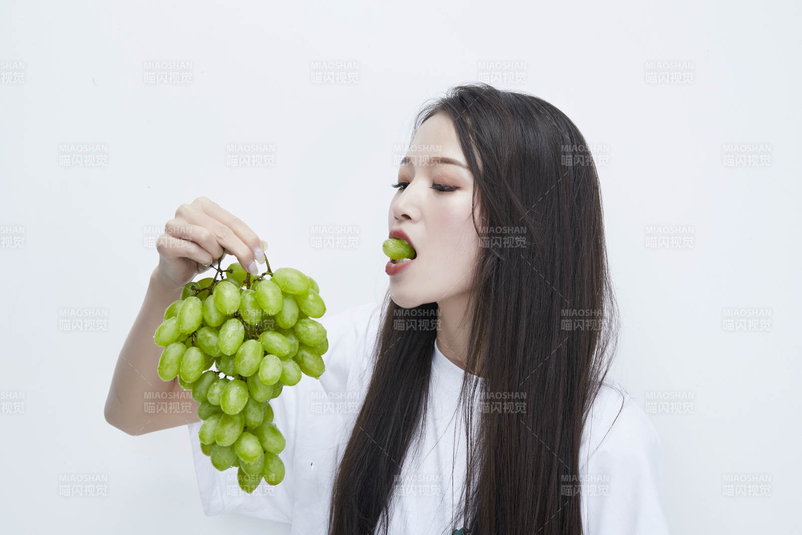吃葡萄的穿白色長T血衫的長發可愛少女人像
